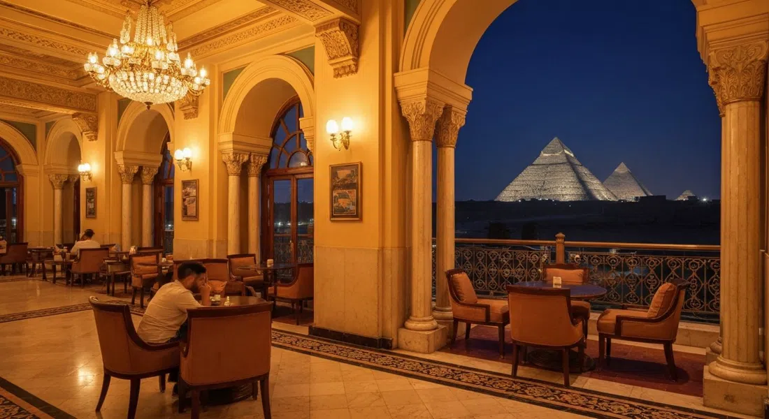 el Sultan Lounge en el Marriott Mena House de noche, luz cálida sobre interiores dorados con las pirámides iluminadas visibles a través de las ventanas